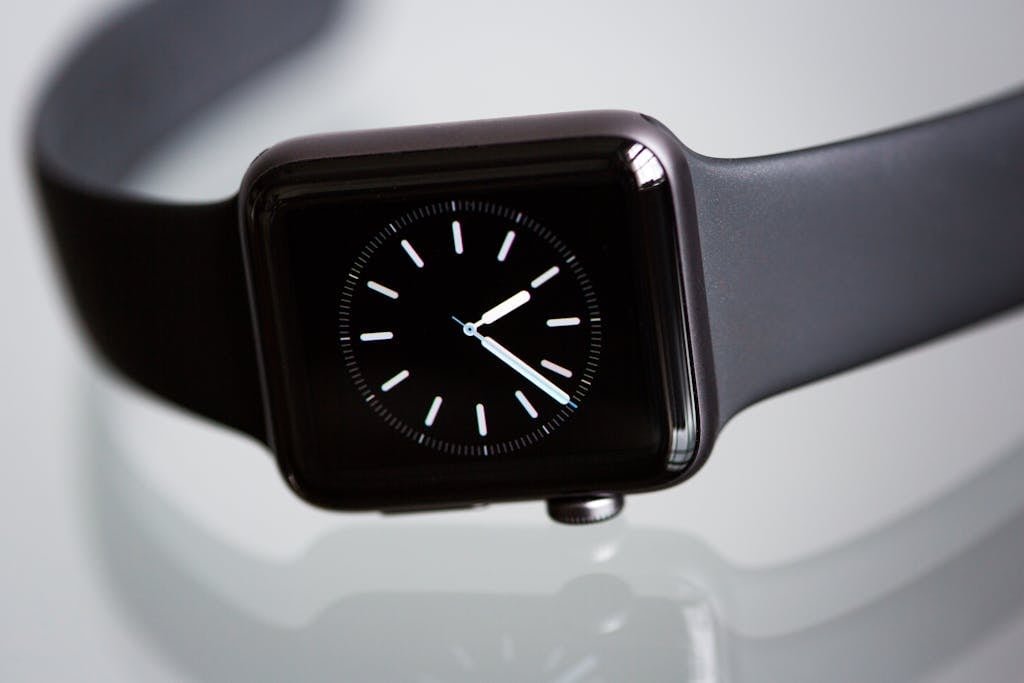 Close-up of an elegant black smartwatch with a minimalist classic dial on a light background.