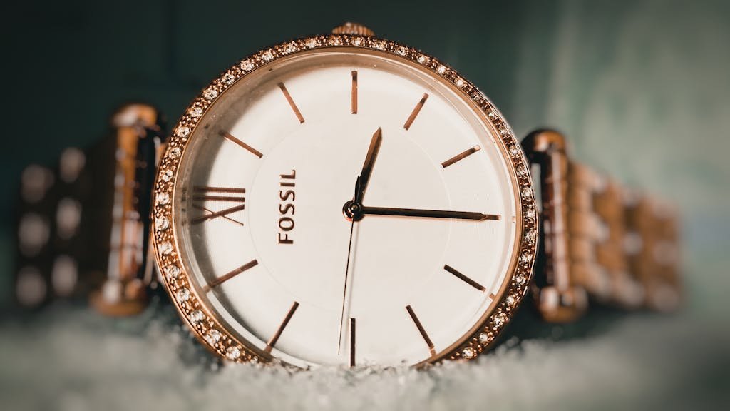 Close-up of an elegant Fossil wristwatch with a gold bezel and sparkling details, captured in Armoor, India.